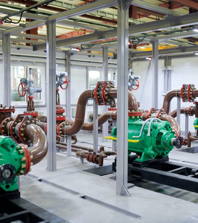 Wide angle shot of empty factory workshop with pipes and mechanisms, copy space